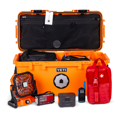 Orange YETI cooler with various items including a red first aid kit and black fan on a white background